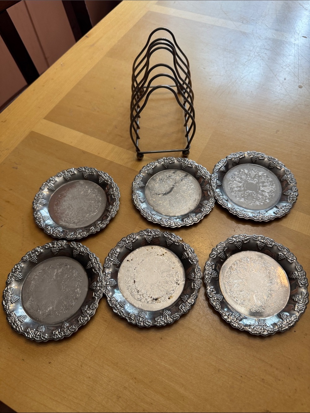 six vintage silver-plated drink coasters with ornate, embossed floral